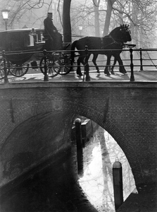 361206 Afbeelding van een koets van Stalhouderij Schoonhoven-Buytendijk op een brug over de Nieuwegracht te Utrecht.